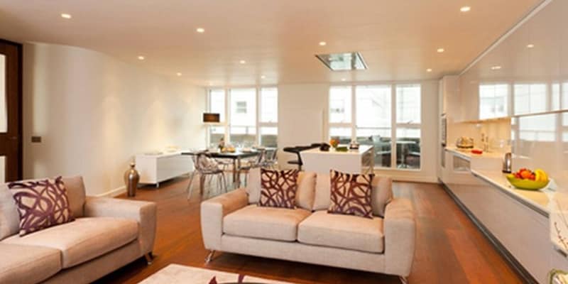St Martin’s Courtyard Apartments, Covent Garden: Dining table behind pale sofa in open room
