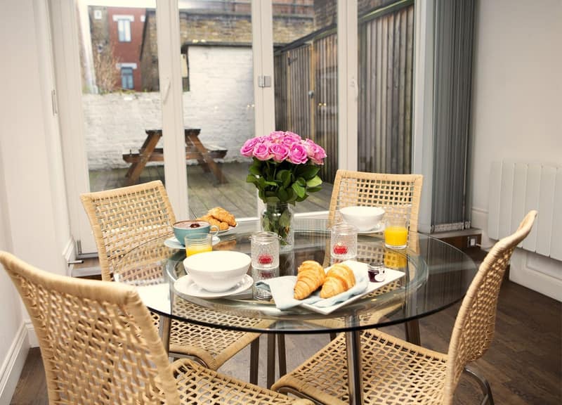 Trafalgar Square Apartments, St Martin’s Lane, Covent Garden: Round dining table set beside tall windows