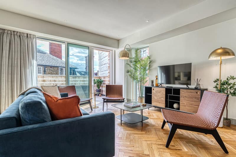 Westminster Apartments, Westminster: Living room with orange armchair and dining area