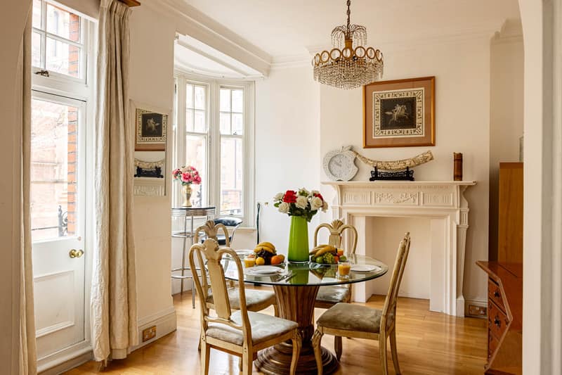 70 Duke Street Two Bedroom Apartment, Mayfair: Dining room with wooden table and chandelier