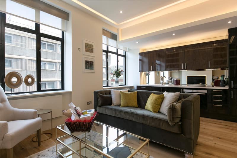 The Armitage Marylebone, Marylebone: Living room with dark sofa and large windows