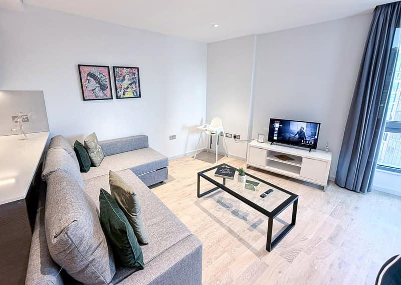 Camley Street Three Bedroom Apartment, King's Cross: Living room with sofa and small dining table