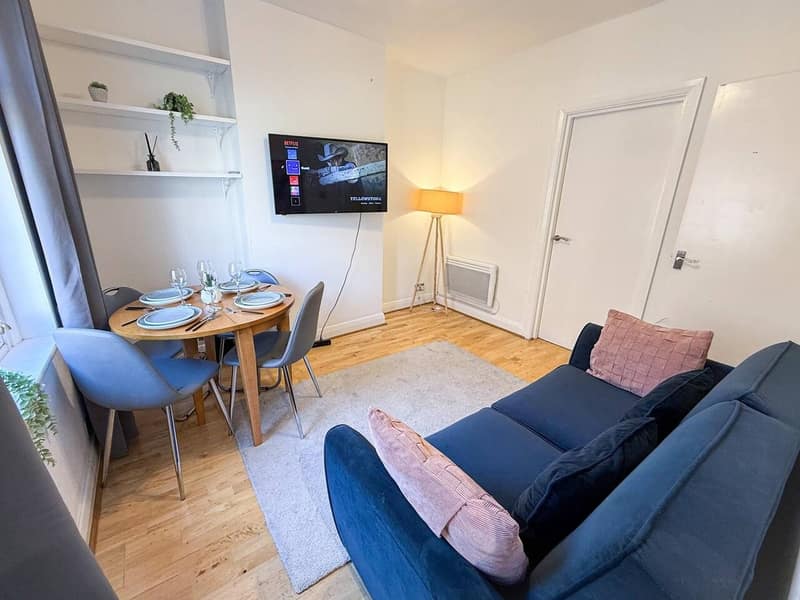 Hackney One Bedroom Apartment, East London: Living room with sofa beside round dining table