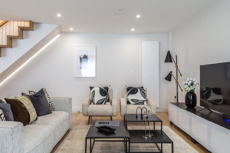 Hazlitt Mews Four Bedroom House, Kensington: Living room with sloping ceiling and staircase