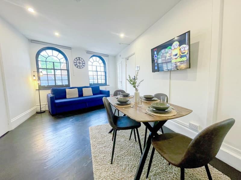 Old Street Apartment Three, Shoreditch: Dining area beside sofa and arched windows
