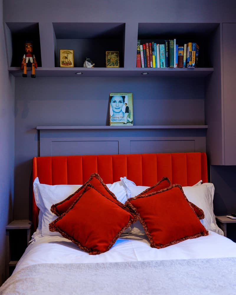 Vancouver Hotel & Studios, Bayswater: Bed beneath a dark bookcase and reading lights