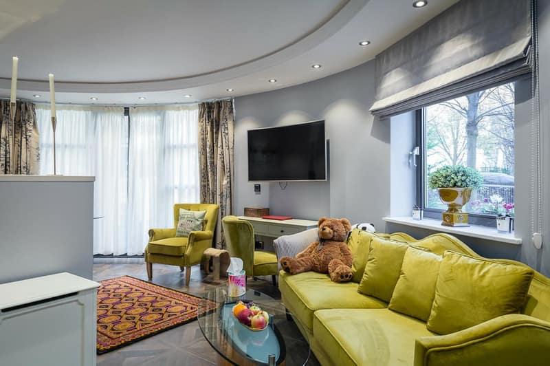 Vincent Street Garden Apartment, Westminster: Living room with green sofa beside patio doors