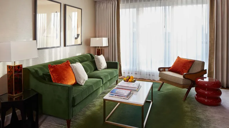 Cheval Gloucester Park, Kensington: Cheval Gloucester Park: One-bedroom living room with a green sofa and full-height windows, photo 1